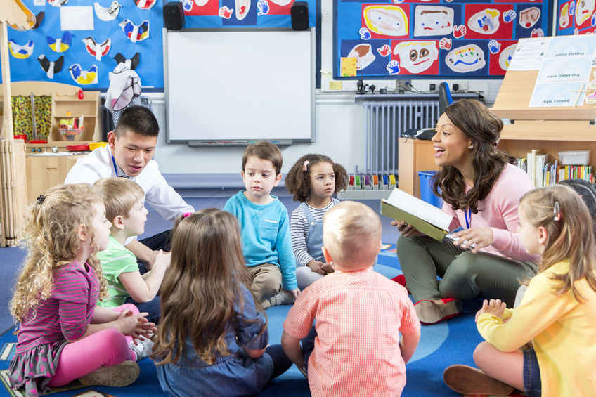 bunch of children in daycare being read a book